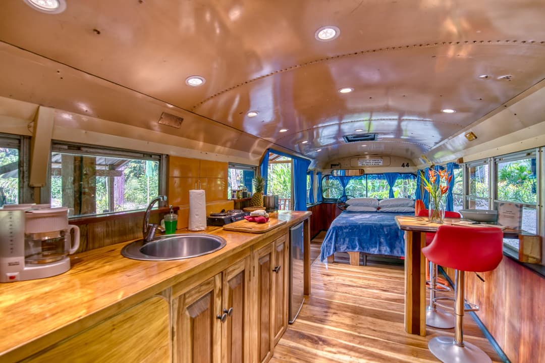Bathroom carved out of the old emergency-door space — hot-water shower and flush toilet, wooden ceiling